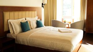 a hotel room with a large bed with blue pillows at The 33rd Executive Suites in Thimphu