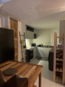 - une cuisine avec une table en bois dans une chambre dans l'établissement Modern duplex 5 minutes from downtown, à Fort-de-France
