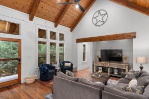 a living room with a couch and a tv at Life is Gruene-Riverfront Luxury-1Mi To GrueneHall in Gruene