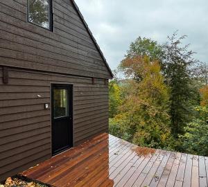 a barn with a door and a wooden deck at Gites Douillets Chalet du Vicomte in Houyet +4 photos