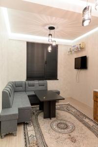a living room with a couch and a table at Cozy Spot in Khujand