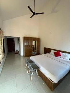 une chambre avec un grand lit avec un ventilateur de plafond dans l'établissement Kawari Resort, à Gokarna