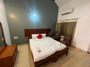 - une chambre avec un lit doté de draps blancs et d'oreillers rouges dans l'établissement Kawari Resort, à Gokarna