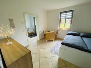 a bedroom with a bed and a table and a desk at Landgut Ziegler in Friesack