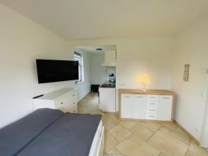 a bedroom with a bed and a flat screen tv at Landgut Ziegler in Friesack