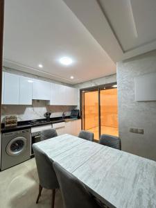 a kitchen with a table and chairs in a room at Agadir Vibes 3 appartements & 1 studio modernes au cœur de la ville in Agadir