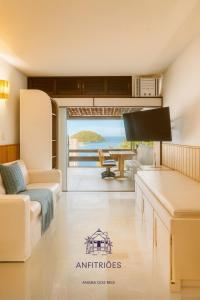 a living room with a view of the ocean at Anfitriões Angra- Flat com Vista Espetacular na Praia Grande in Angra dos Reis