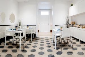 a white kitchen with white tables and white chairs at L'Opera Buffa in Palermo