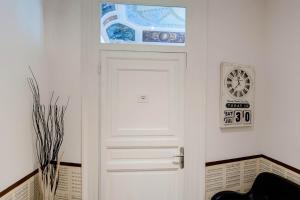 une porte blanche dans une pièce avec une horloge sur le mur dans l'établissement L'Opera Buffa, à Palerme