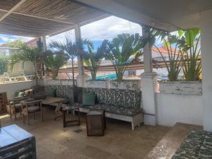a patio with a couch and tables and palm trees at Casa Ebano 967 in Cartagena de Indias