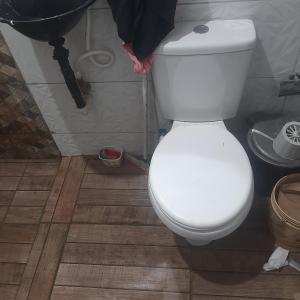 une salle de bain avec des toilettes blanches dans une chambre dans l'établissement Quartos na Band, à Telêmaco Borba