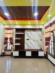 uma televisão de tela grande em uma sala com janelas em Palm Villas Jaffna em Jaffna