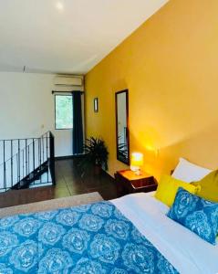 Un dormitorio con una cama y una pared amarilla. en Cozy and Peaceful Beach Apartment, en Playa Grande