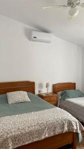 a bedroom with two beds and a fan at La Pollera in Cehegín