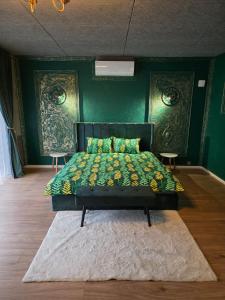 Un dormitorio con una cama con una pared verde. en Vinetas Apartments Nr1 Green Royal, en Cēsis