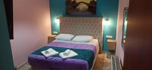 ein Schlafzimmer mit einem lila Bett, auf dem zwei Handtücher liegen in der Unterkunft Tokastro2 in Arachova