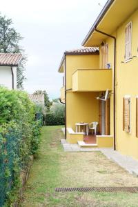 a yellow house with a table on the side of it at Atlantic in Bardolino
