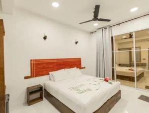 a bedroom with a bed with a ceiling fan at Oak Thoddoo in Toddu Atoll