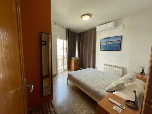 Un dormitorio pequeño con una cama y una ventana. en Casa la Luna, en Badalona