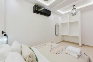 a white living room with a couch and a tv at Maison Joudia in Marrakech