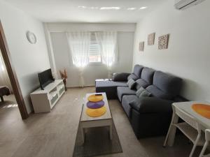 a living room with a couch and a table at HUELIN PLAYA in Málaga