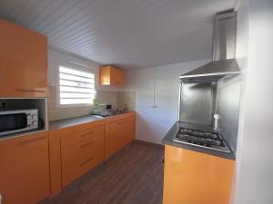 a kitchen with a stove top oven in a kitchen at Maison individuelle de plain-pied in Schœlcher