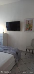 a bedroom with a bed and a chair and a flat screen tv at appartamento a careggi casa diamante in Florence