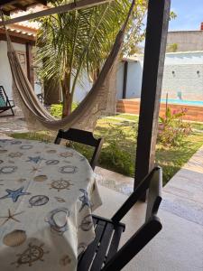 a table and chairs with a table and hammock at Sweet House Búzios in Búzios