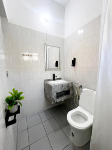 a white bathroom with a sink and a toilet at Pajevista in Paje