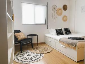 a small bedroom with a bed and a chair at Casa C`Alma - Downtown Olhão Apartment with Pool in Olhão +24 photos