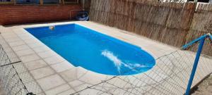 a blue swimming pool with a fence around it at BelloLugar in San Rafael