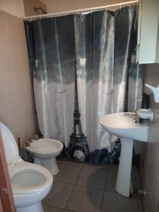 a bathroom with a toilet and a sink and the eiffel tower at BelloLugar in San Rafael +6 photos