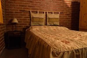 a bedroom with a bed with a brick wall at BelloLugar in San Rafael