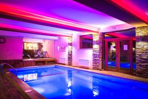 uma piscina numa casa com luzes roxas em Elina Hotel em Pamporovo