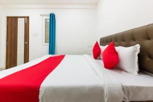 a bedroom with a large bed with red pillows at Hotel O Qualia Inn Kondapur Near Botanical Garden in Hyderabad +34 photos