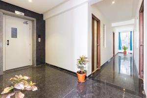 an empty hallway with potted plants and a door at Hotel O Qualia Inn Kondapur Near Botanical Garden in Hyderabad +25 photos