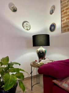 a room with a table with a lamp and plates on the wall at Dimora Boezio7, cozy and charming place in center with private parking in Pavia