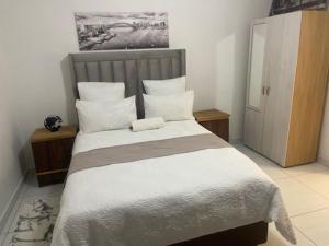ツメブにあるVictoria Guesthouse Tsumebの白いシーツと枕が付いた大きなベッドのある寝室