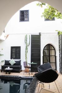 a patio with a table and chairs next to a pool at Riad Ajmal in Marrakech