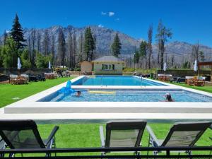 une piscine avec des chaises et des gens dans l'eau dans l'établissement Complejo Turistico Paralelo 42, à Lago Puelo 14 autres photos