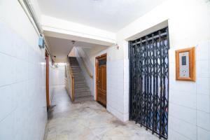 Un pasillo vacío con una escalera y una puerta de metal. en Hotel O Sree Radha Lodge Near Snow World, en Hyderabad