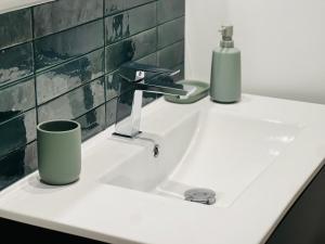 a white sink with two cups on top of it at City Loft Valence hyper-centre in Valence