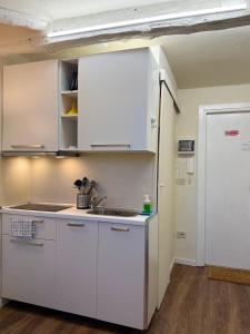 a kitchen with white cabinets and a sink at Little House Amedeo in Turin