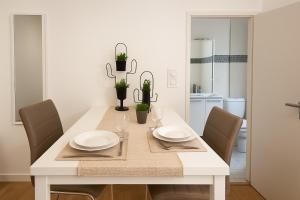 a white dining room table with two plates and chairs at Casa Terracotta 2 people -Central in Mâcon