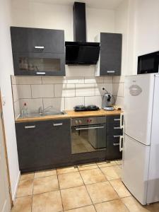 a kitchen with a sink and a refrigerator at Flandre 01 in Roubaix