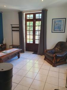 a living room with a leather chair and a table at Gîte de la Chazotte in Bussière-Dunoise