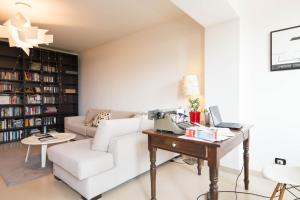 a living room with a white couch and a desk at Appartamento e terrazza vista mare con giardino in Finale Ligure