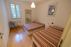 a bedroom with two beds and a table and a chair at Appartamento e terrazza vista mare con giardino in Finale Ligure