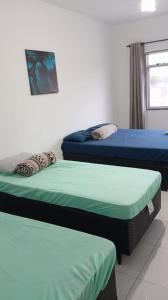 a room with two beds and a window at Suite Brisa 201 in Pedra de Guaratiba