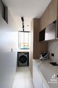 a laundry room with a washing machine and a window at Pimentel frente al muelle con balcón in Pimentel +8 photos